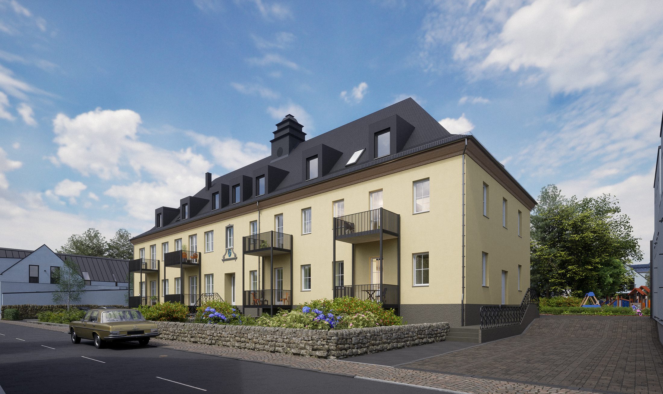 Gelbes Bestandsgebäude mit Mansarddach und Balkonen
